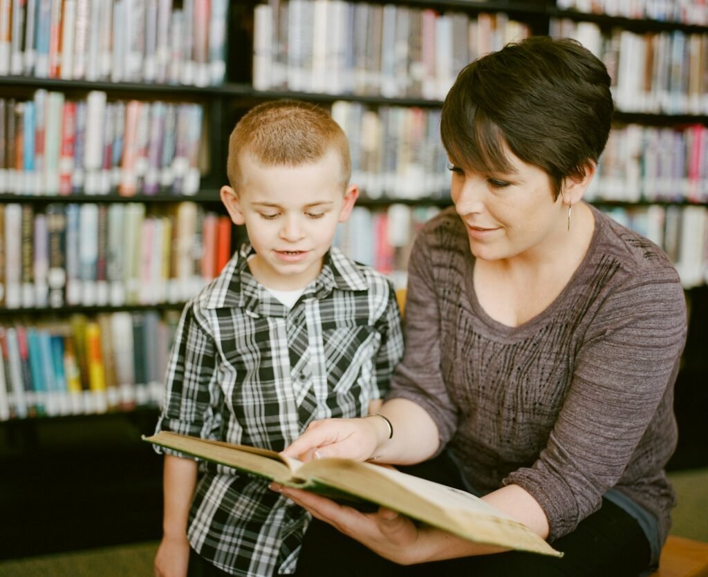 A woman and a child reading a book together in a calm library corner