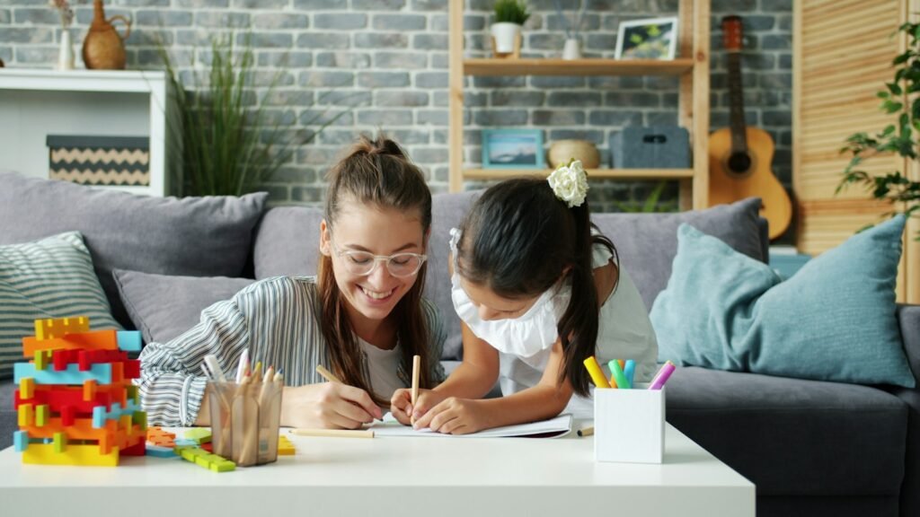 Mother and child drawing together on a couch at home